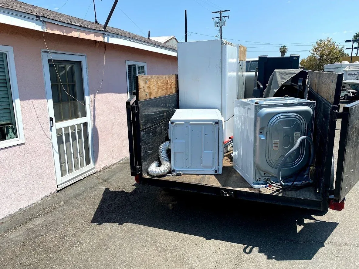 Bin Bandits crew sliding a refrigerator out of a kitchen on an appliance dolly
