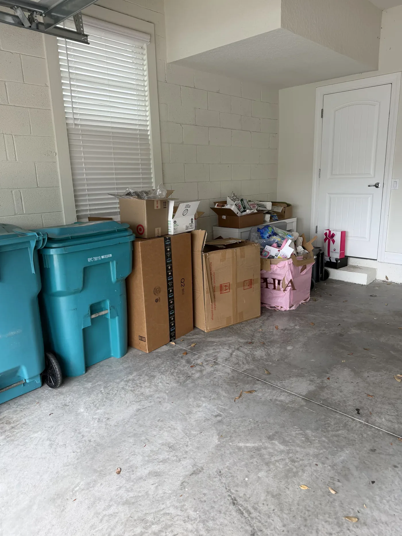 Packed two-car garage with boxes and furniture covering the floor