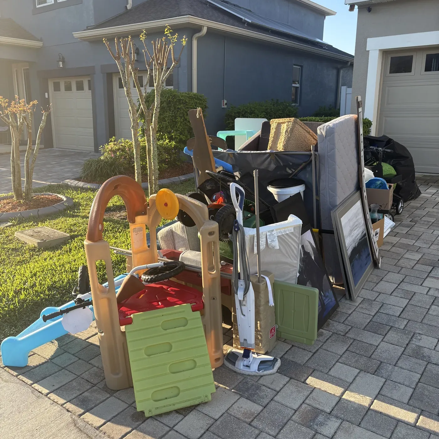 Garage contents pulled out onto the driveway at the start of a spring cleanout