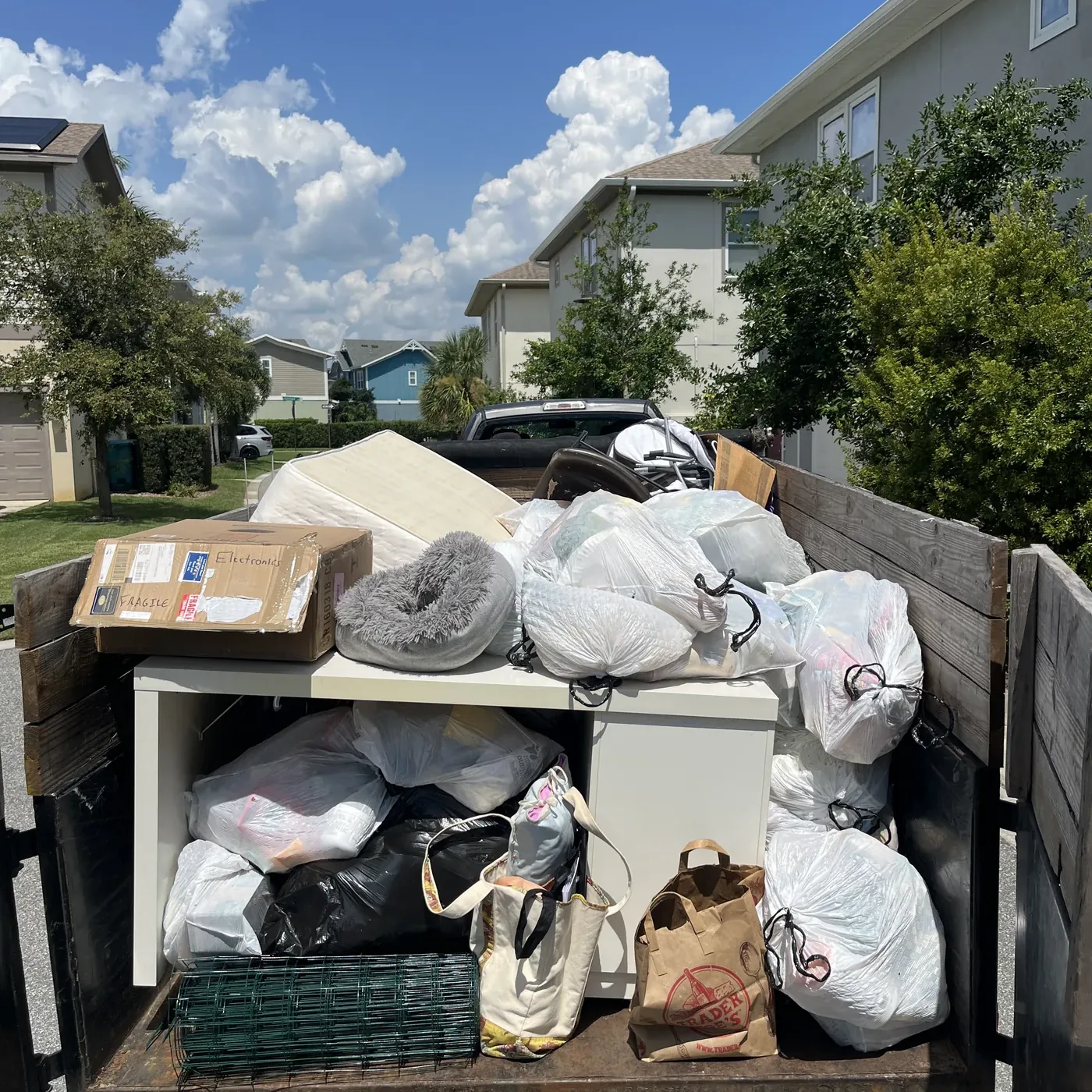 Junk removal crew sorting donated furniture and recyclable items at a facility